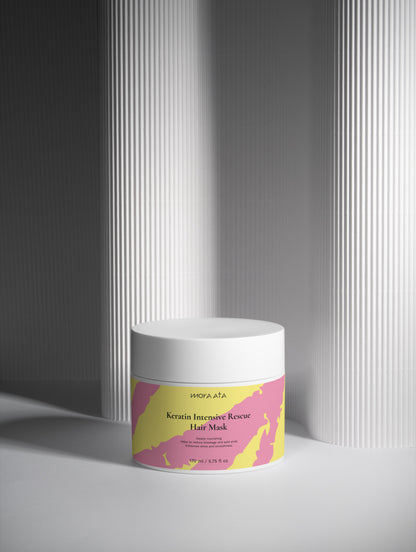 Hair mask jar with a colorful label on a gray background