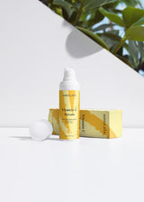 MORA ATA Vitamin C serum with packaging on a white surface with greenery in the background