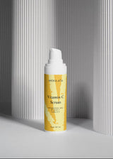Mora Ata Vitamin C Serum bottle with yellow label against a gray background