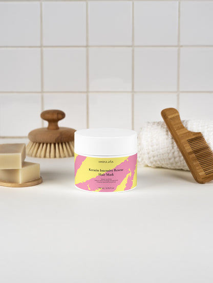 Keratin Intensive Rescue Hair Mask on a bathroom counter with a brush and soap in the background.