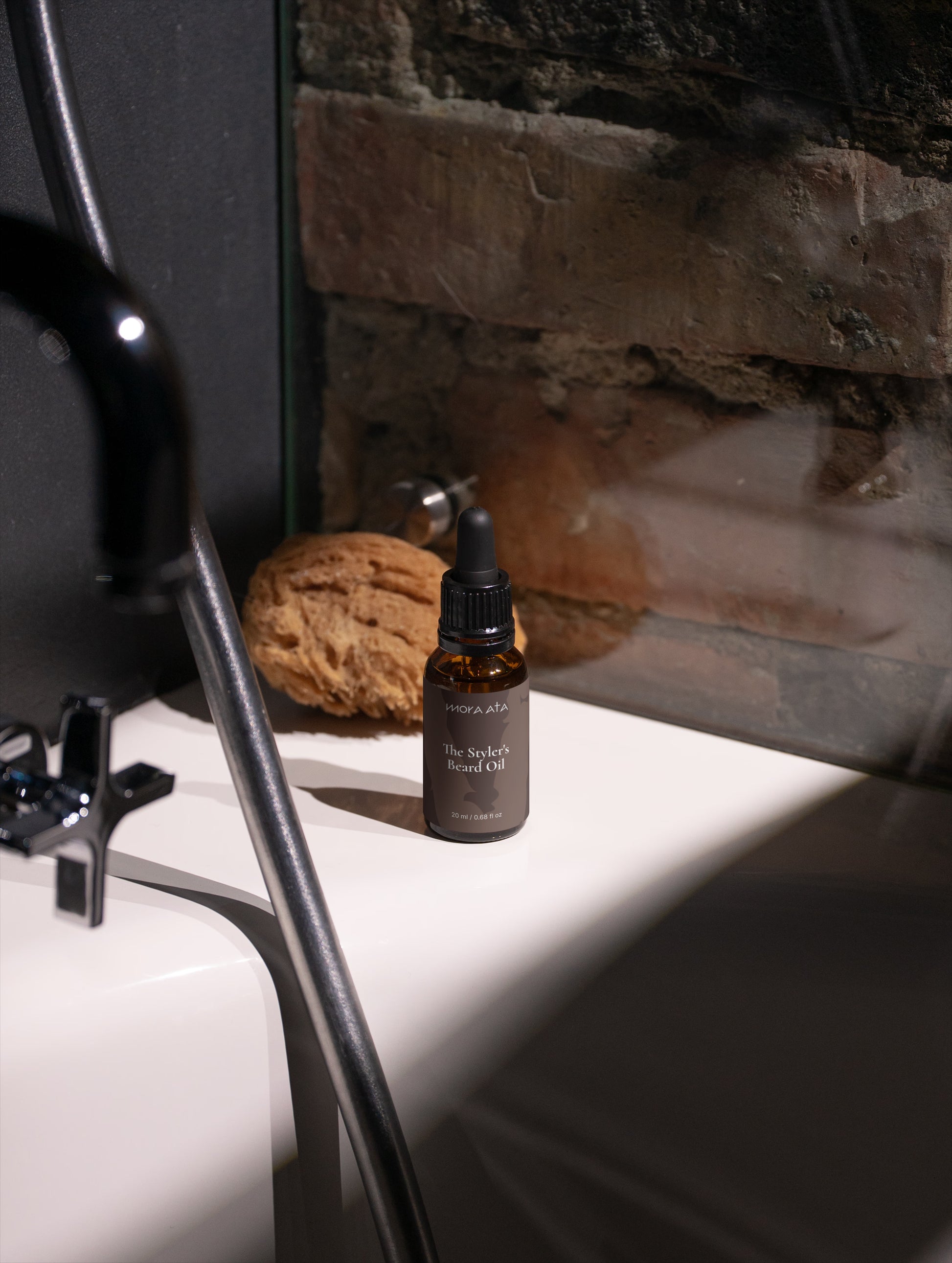 Mora Ata The Styler's Beard Oil bottle  on a white surface with a stone wall background